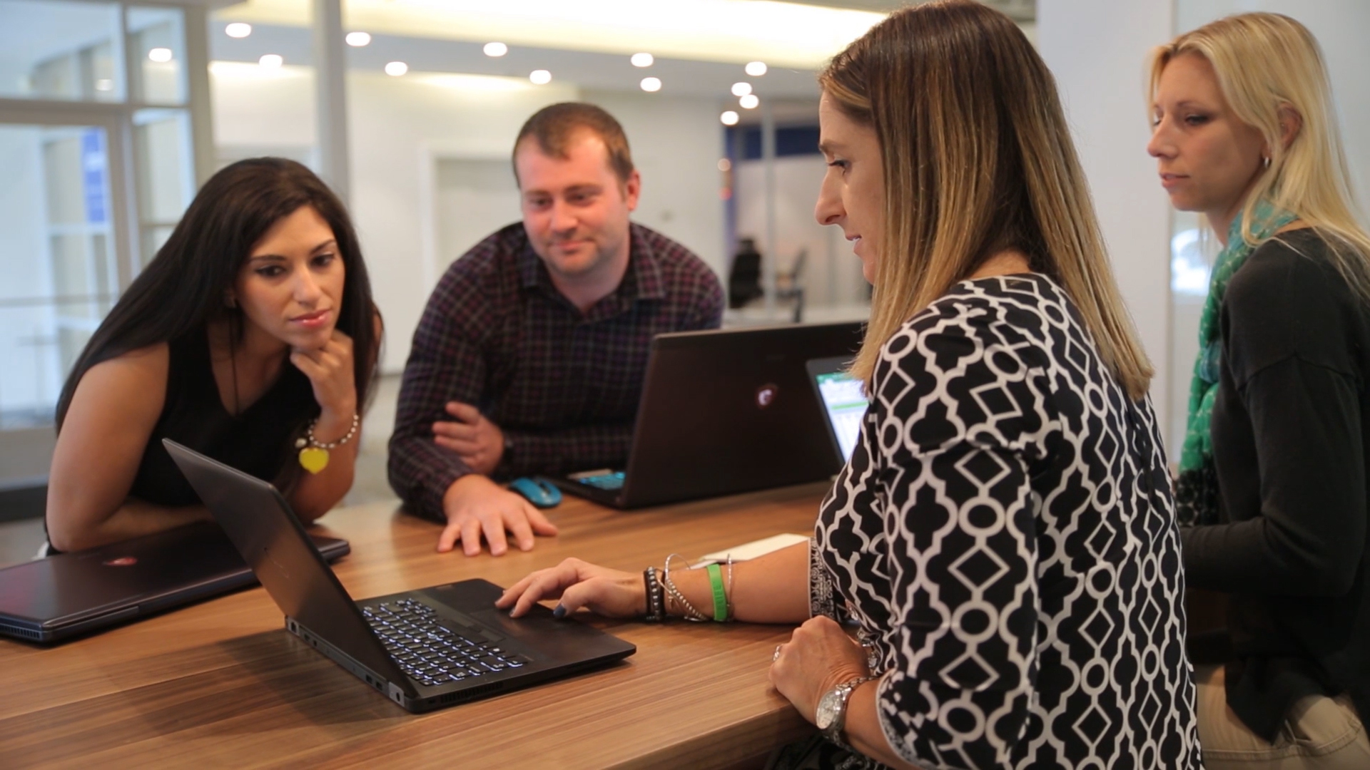 4 people collaborating over a laptop