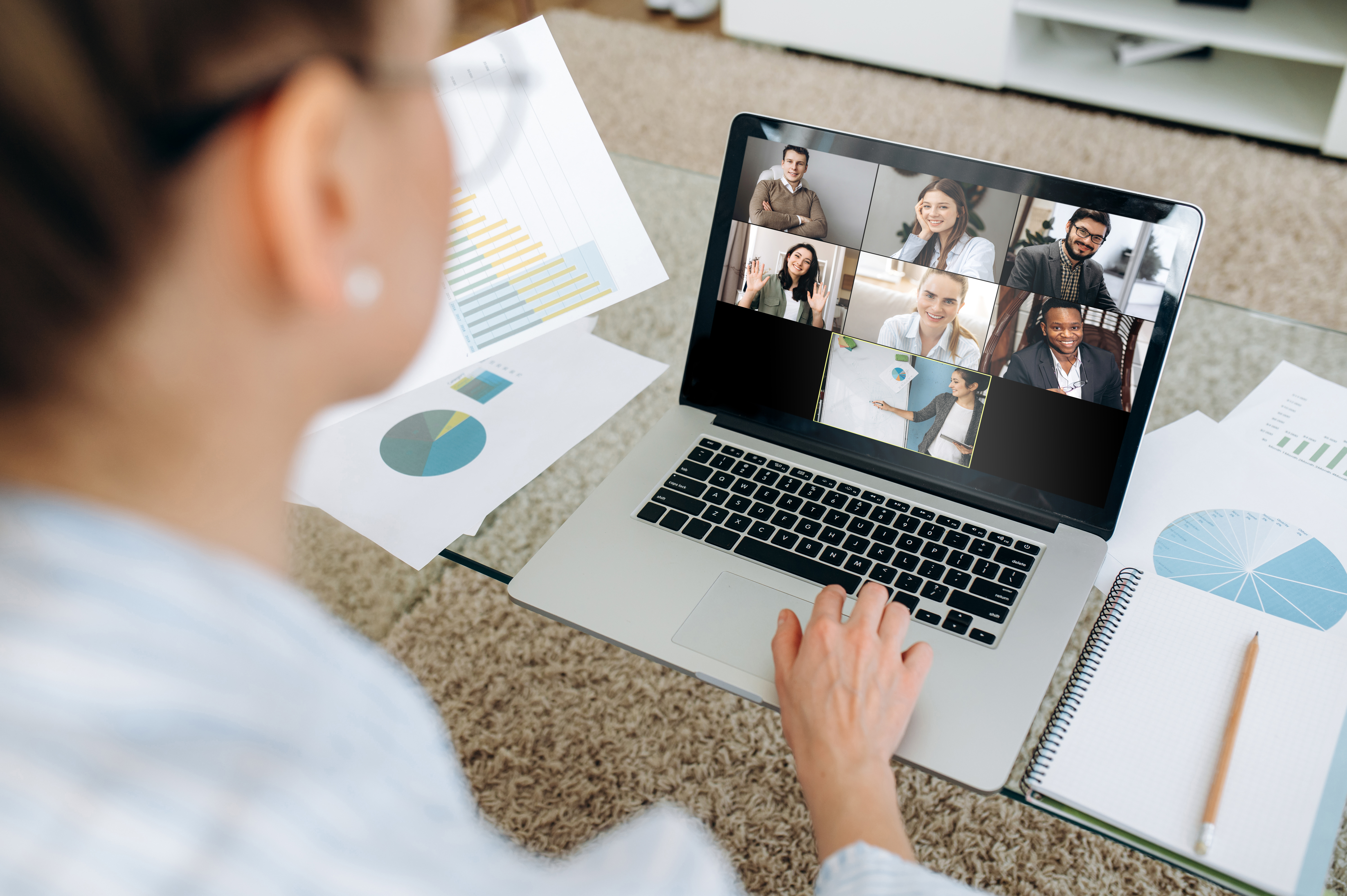 woman working on laptop on video call with multiple people