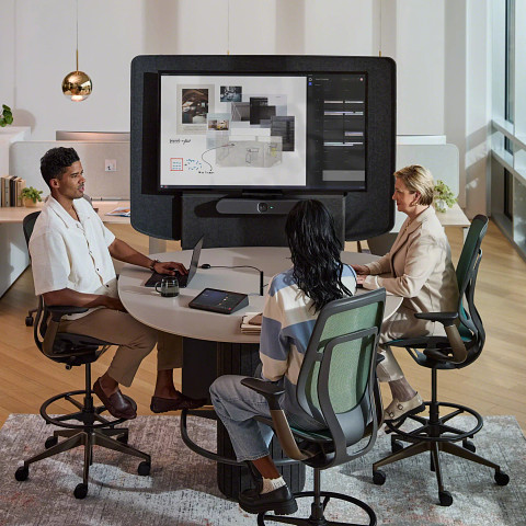 3 colleagues gather around technology integrated table to collaborate